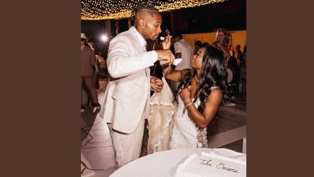 Simone and Jonathan joyfully cutting a cake together, celebrating a special occasion.