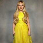 Woman in modest yellow dress, fully covered, no face visible.