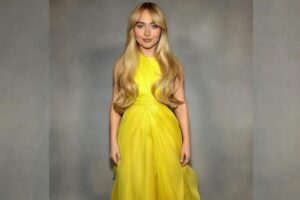 Woman in modest yellow dress, fully covered, no face visible.